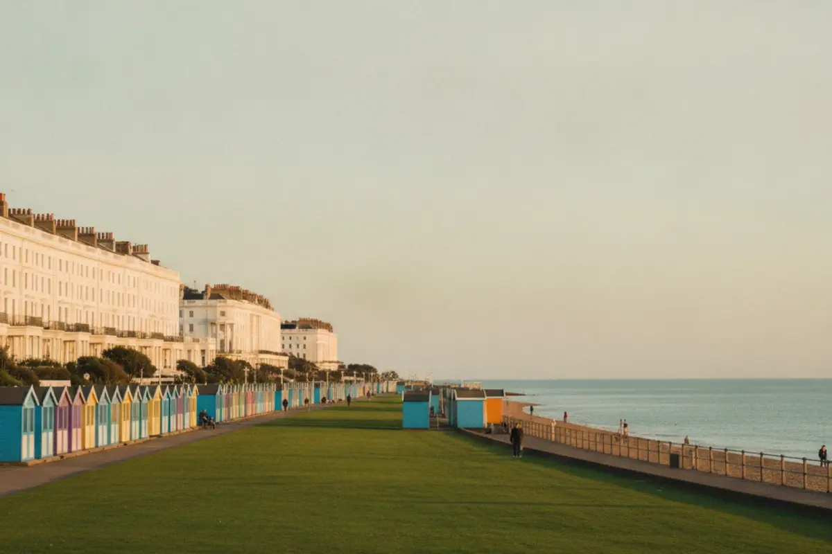 Colourful beach huts on Hove seafront lawns with Regency terraces behind